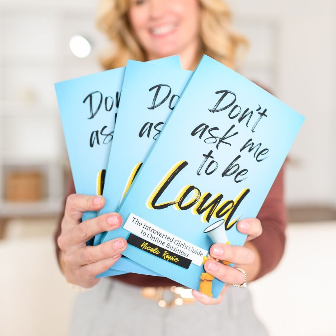 Copywriter, Nicole Kepic, holding her new business book for female introverted entrepreneurs.